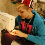 A student works in the costume shop on a garment for an upcoming show.